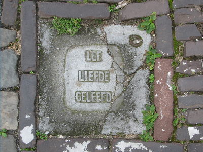 833265 Afbeelding van een tegel met de tekst 'LEF LIEFDE GELEEFD', in het plaveisel op de Brigittenstraat ter hoogte ...
